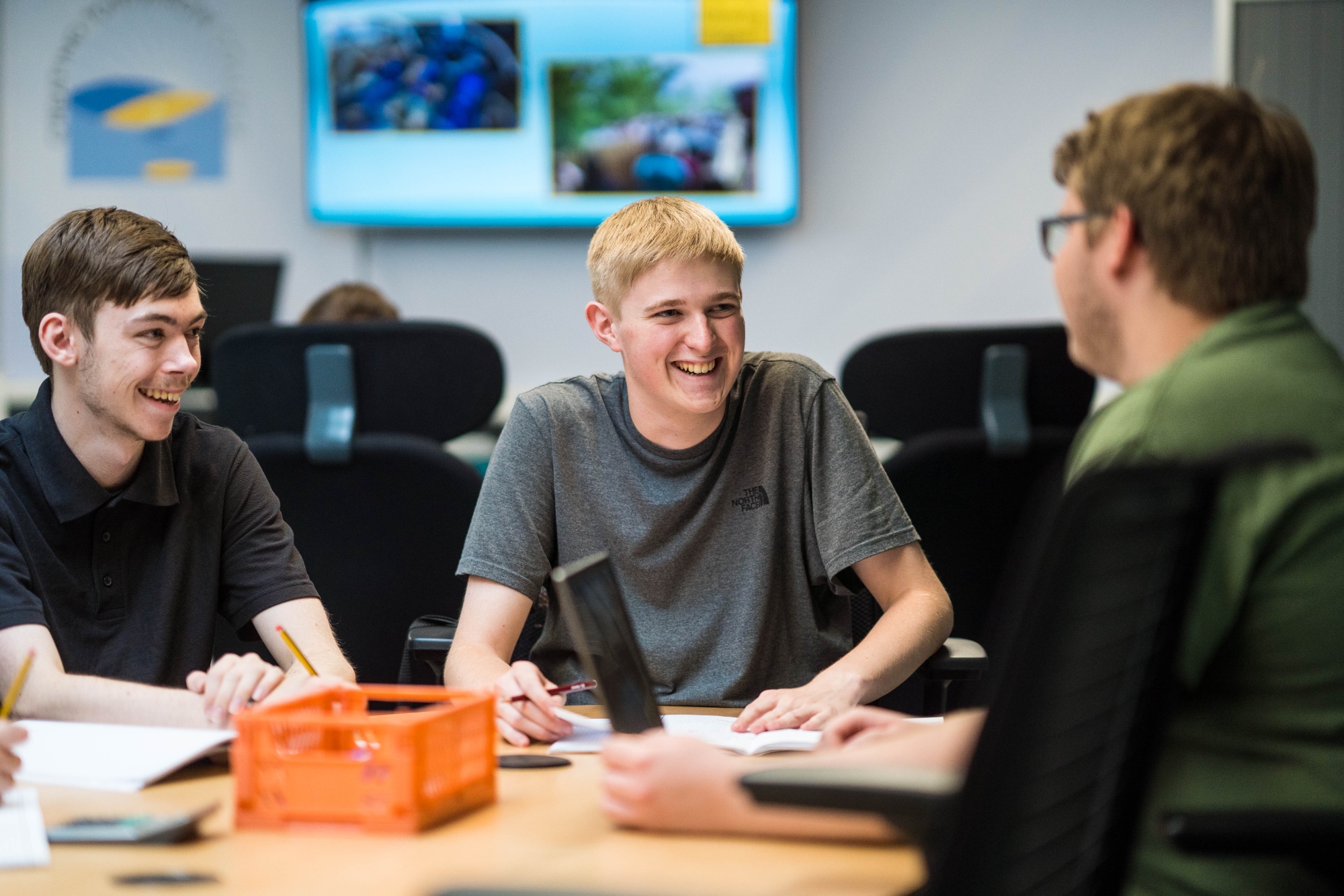 A photo of three happy students working together as a group