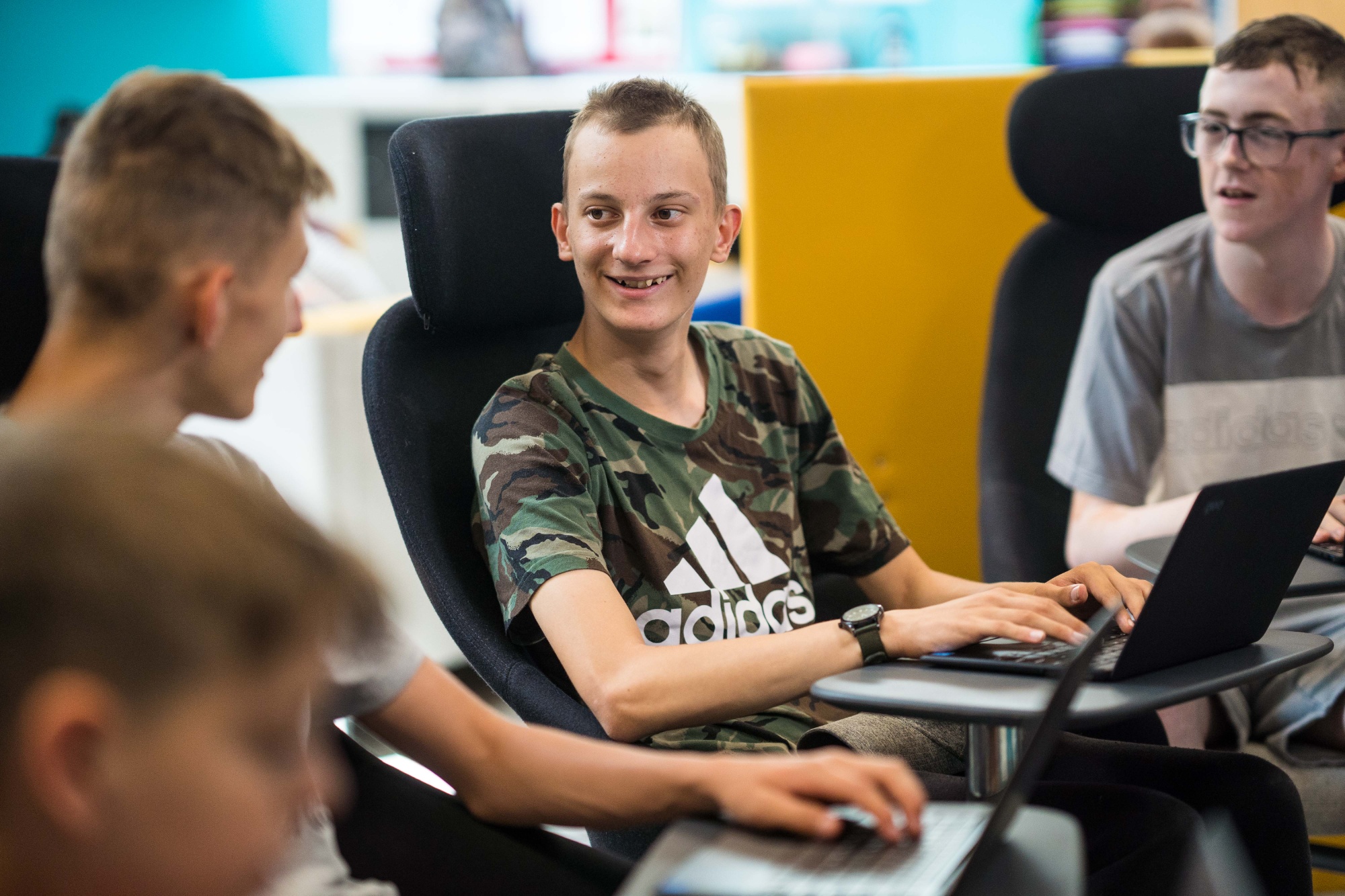 Happy students working on laptops.