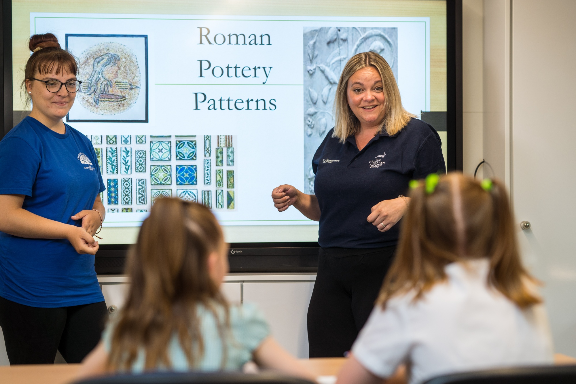 Student supporting a group of young visitors to Chester House with a session about Roman Pottery Patterns