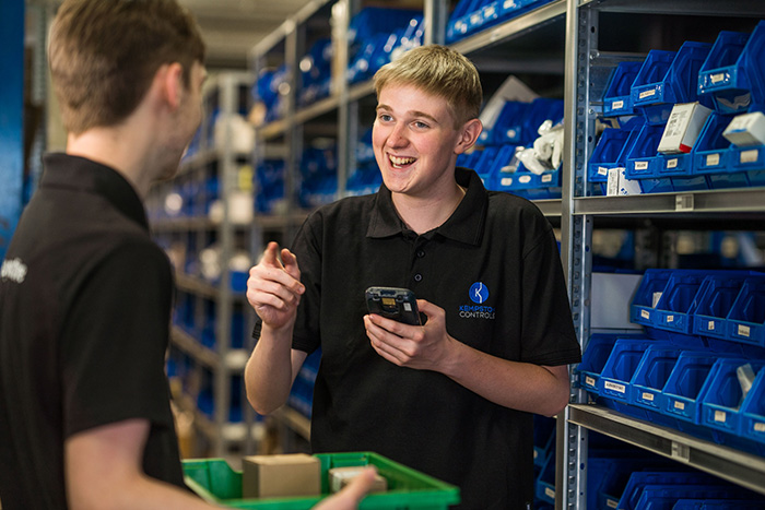 Student sharing a joke with a colleague while working in a store room